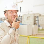 man in construction site talking into a walkie talkie